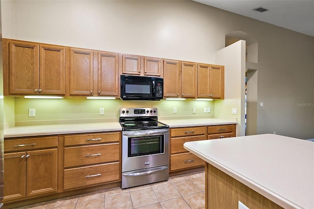 kitchen featuring light tile patterned flooring and stainless steel range with electric stovetop