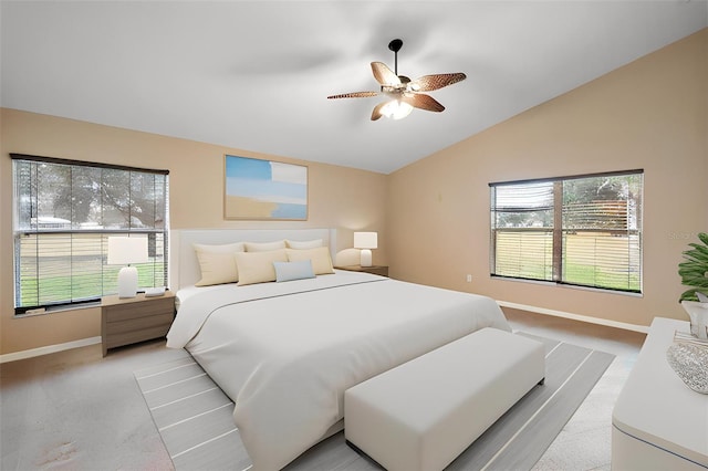 bedroom featuring light colored carpet, ceiling fan, vaulted ceiling, and multiple windows