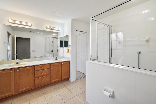 bathroom featuring tile patterned flooring, vanity, and walk in shower