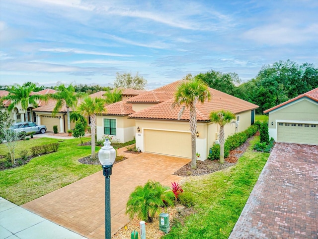 mediterranean / spanish home featuring a front lawn and a garage