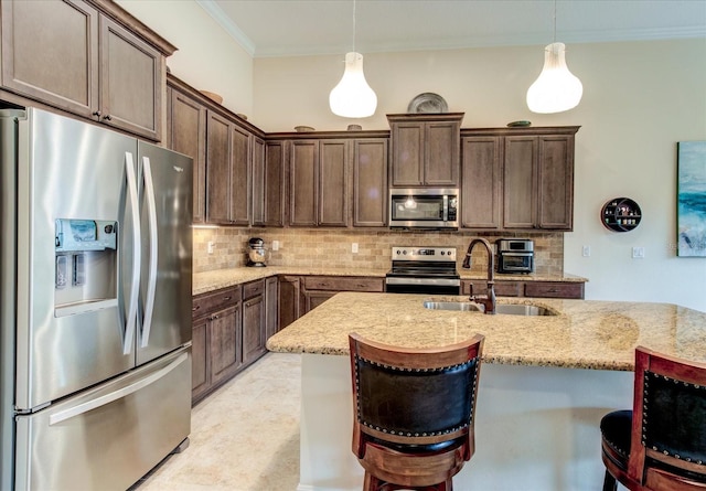 kitchen with appliances with stainless steel finishes, light stone countertops, crown molding, decorative light fixtures, and sink