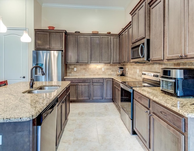 kitchen featuring light stone countertops, appliances with stainless steel finishes, crown molding, and decorative light fixtures