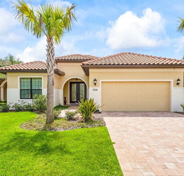 mediterranean / spanish home with a front yard and a garage