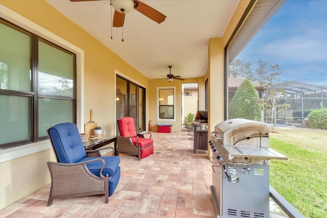 view of patio featuring ceiling fan, grilling area, and glass enclosure