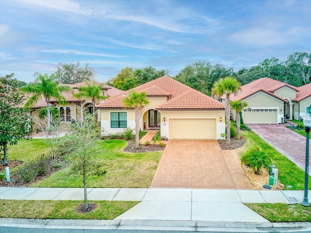 mediterranean / spanish house with a garage and a front lawn