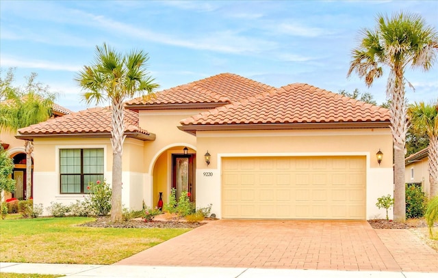 mediterranean / spanish-style home featuring a front yard and a garage