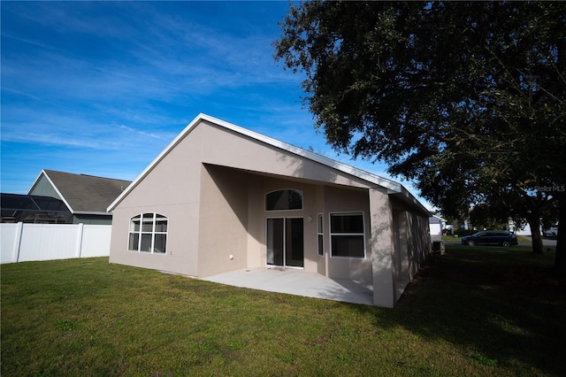 back of property with a yard and a patio