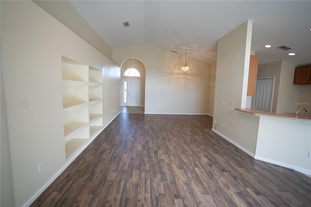 unfurnished living room with lofted ceiling, dark hardwood / wood-style flooring, sink, and built in features