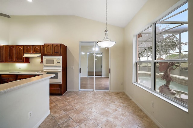 kitchen featuring lofted ceiling, light tile patterned floors, hanging light fixtures, and white appliances