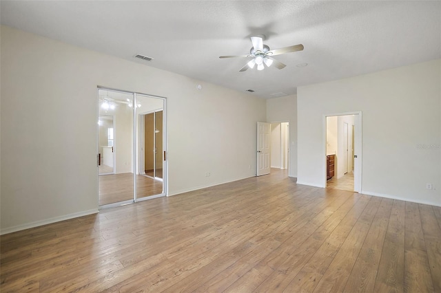 spare room with ceiling fan, light hardwood / wood-style floors, and a textured ceiling