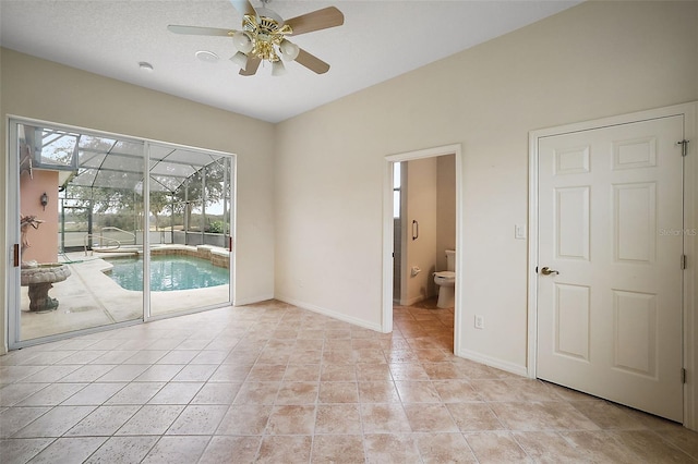 spare room with ceiling fan and light tile patterned flooring