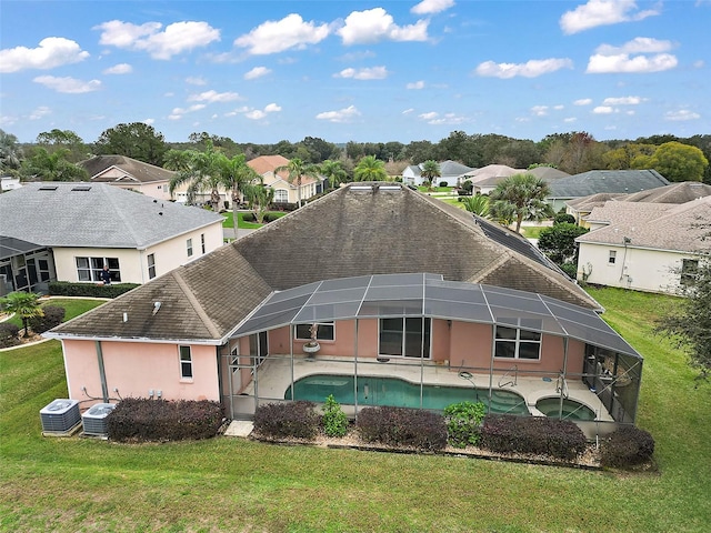 rear view of house with a patio, central air condition unit, a lanai, and a lawn