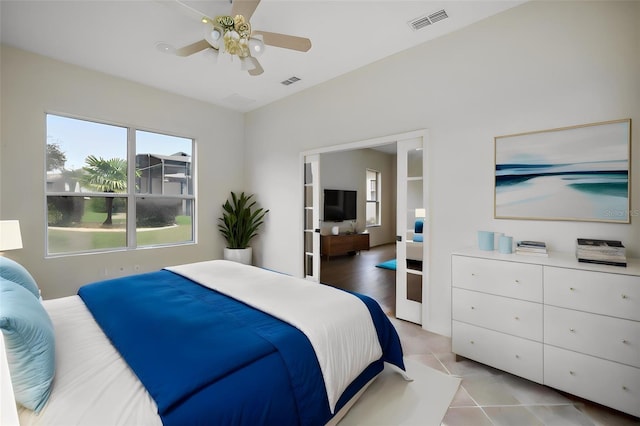 tiled bedroom featuring ceiling fan