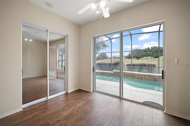 doorway to outside with ceiling fan, a water view, and dark hardwood / wood-style floors