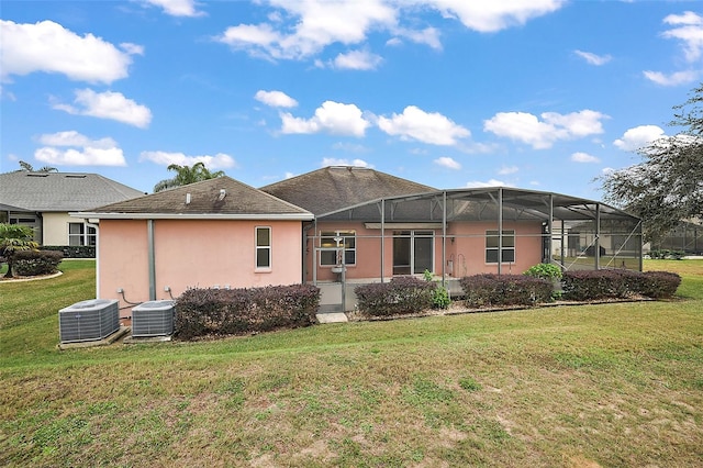 back of house with a lanai, a lawn, and central AC unit