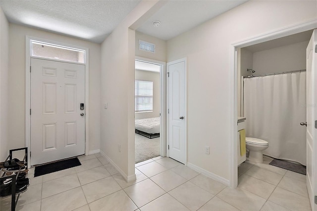 tiled foyer entrance featuring a textured ceiling