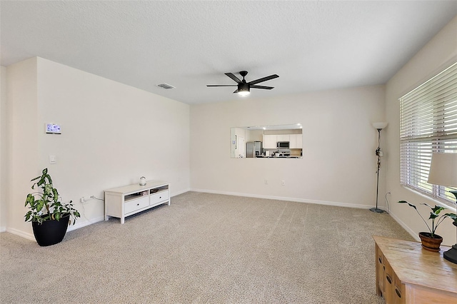 sitting room featuring a textured ceiling, ceiling fan, and carpet floors