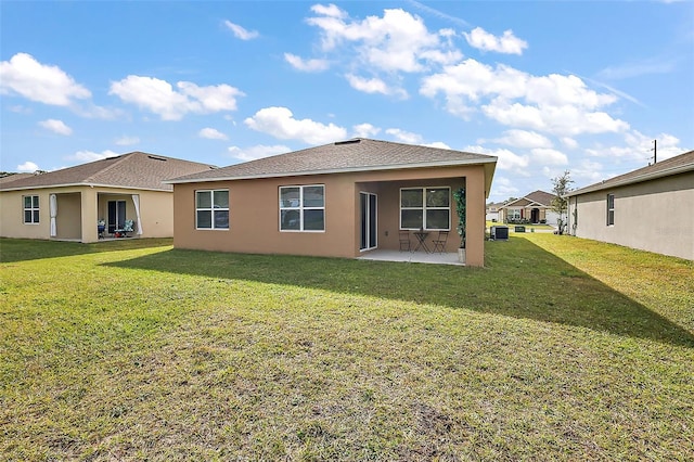 back of property with a lawn and a patio area