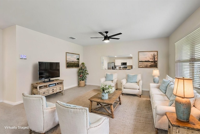 living room with ceiling fan and carpet