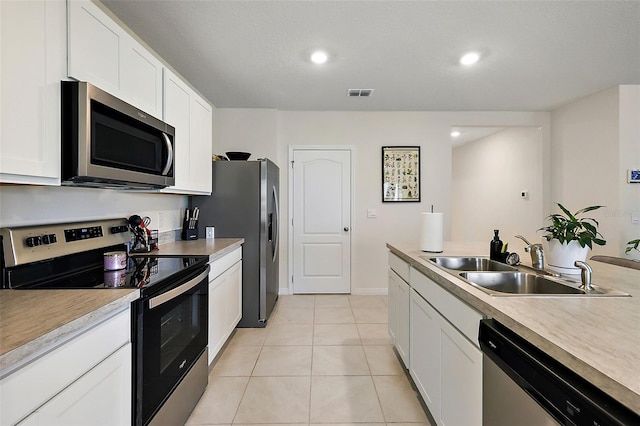 kitchen with white cabinetry, appliances with stainless steel finishes, sink, and light tile patterned flooring