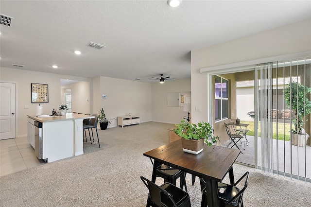 carpeted dining area with a textured ceiling, ceiling fan, and sink