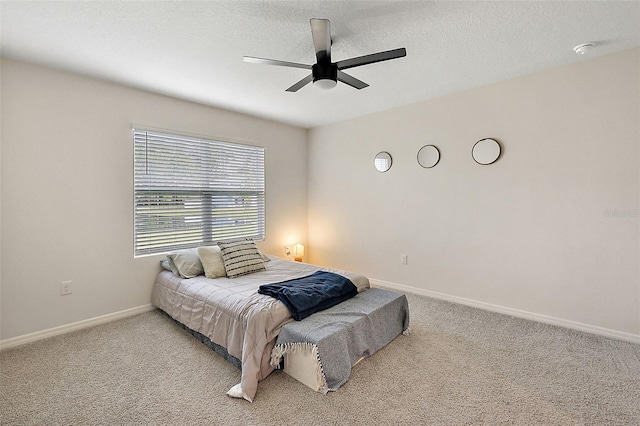 bedroom featuring a textured ceiling, light carpet, and ceiling fan