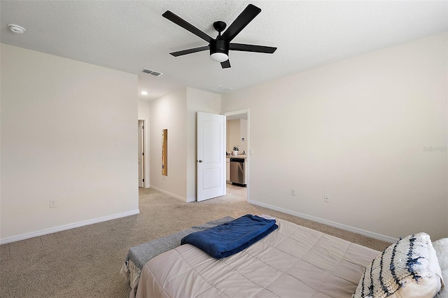 bedroom featuring ceiling fan, a textured ceiling, and light carpet