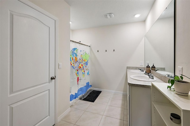 bathroom featuring vanity, walk in shower, tile patterned flooring, and a textured ceiling