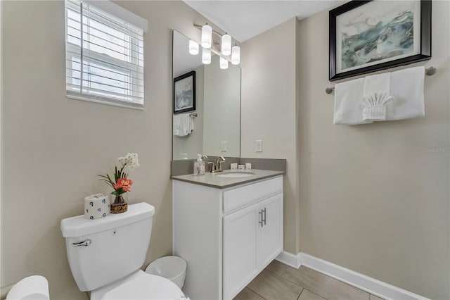 bathroom featuring tile patterned flooring, vanity, and toilet