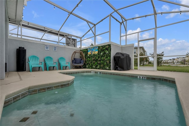 view of pool featuring glass enclosure, grilling area, and a patio area