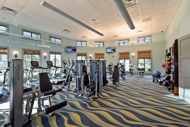 gym featuring carpet and a towering ceiling