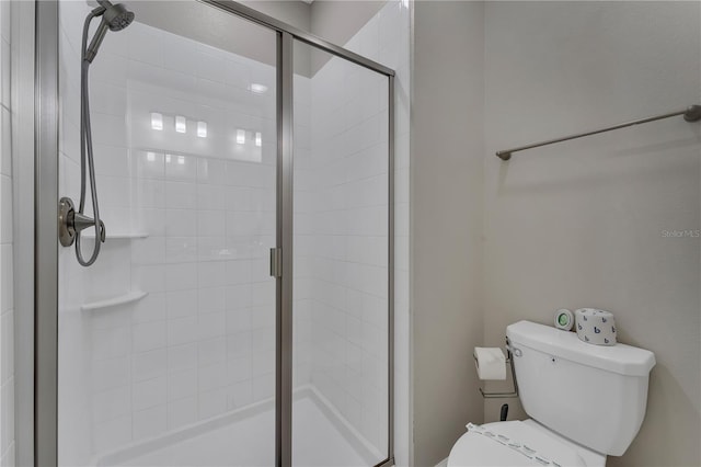 bathroom with toilet and a shower with shower door