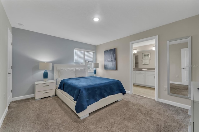 bedroom with light carpet and ensuite bathroom