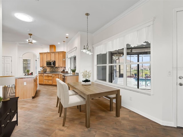 dining space featuring ornamental molding, ceiling fan, a healthy amount of sunlight, and sink