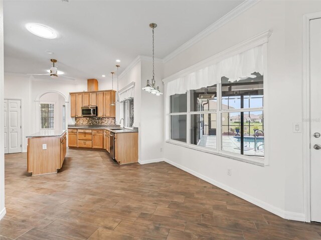 kitchen with pendant lighting, a center island, a healthy amount of sunlight, and appliances with stainless steel finishes