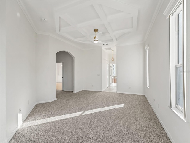 carpeted empty room featuring ceiling fan, a healthy amount of sunlight, ornamental molding, and coffered ceiling