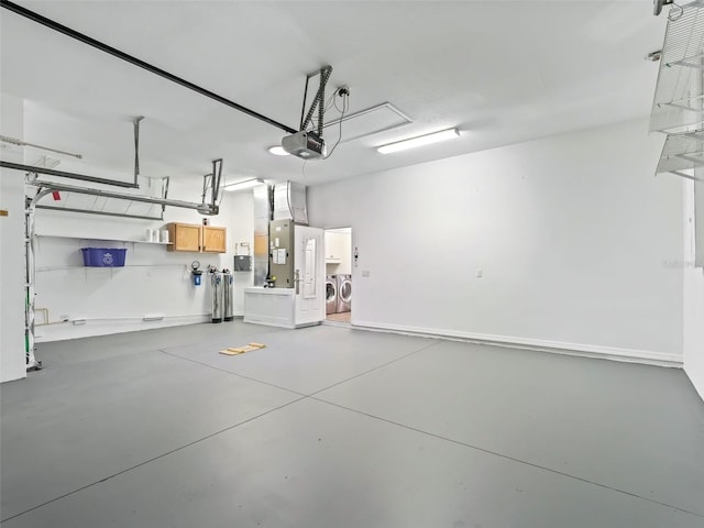 garage with independent washer and dryer and a garage door opener