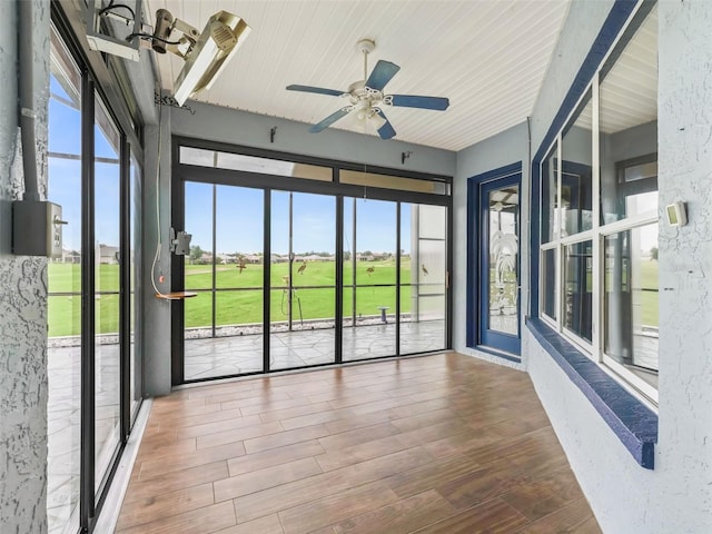 unfurnished sunroom featuring ceiling fan