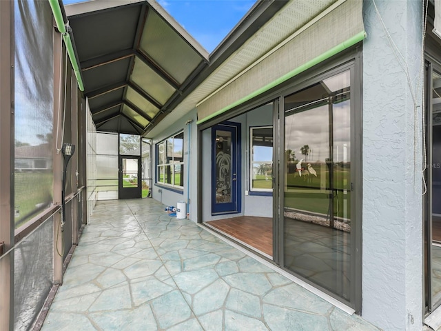 unfurnished sunroom featuring vaulted ceiling