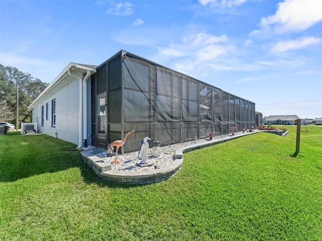 exterior space with glass enclosure and a lawn