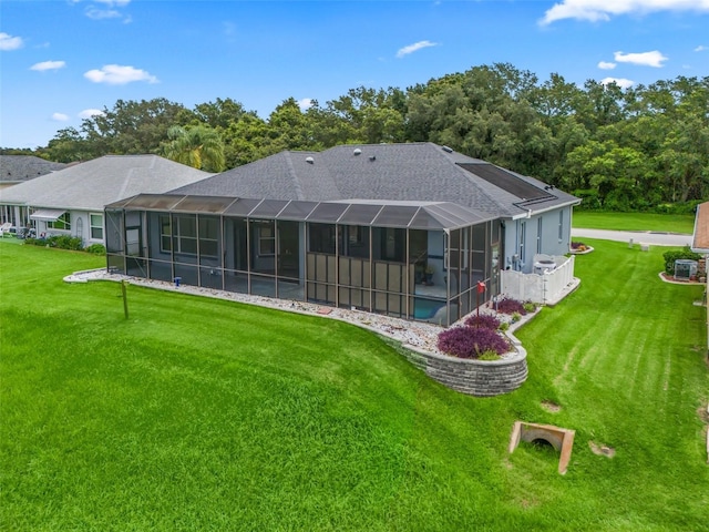 back of house with a lawn, glass enclosure, and central air condition unit