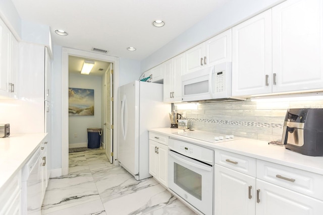 kitchen featuring white cabinets, backsplash, light tile floors, and white appliances