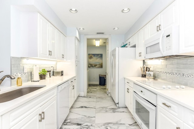 kitchen featuring white appliances, sink, light tile floors, white cabinets, and tasteful backsplash