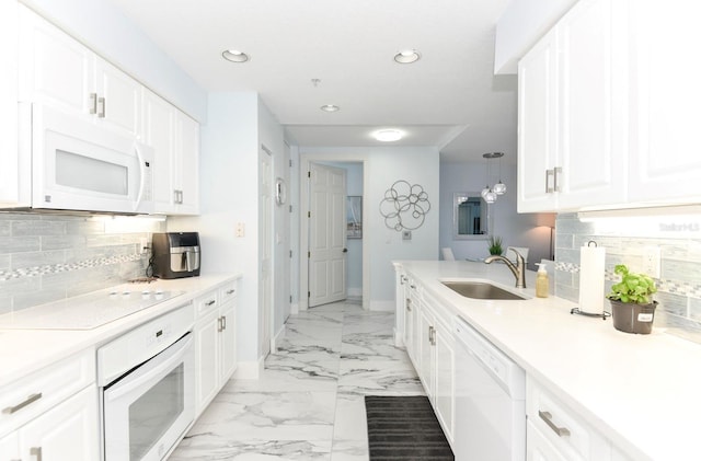 kitchen with white appliances, sink, light tile floors, white cabinets, and tasteful backsplash