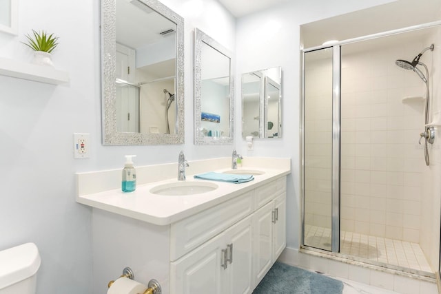 bathroom featuring toilet, a shower with shower door, and oversized vanity