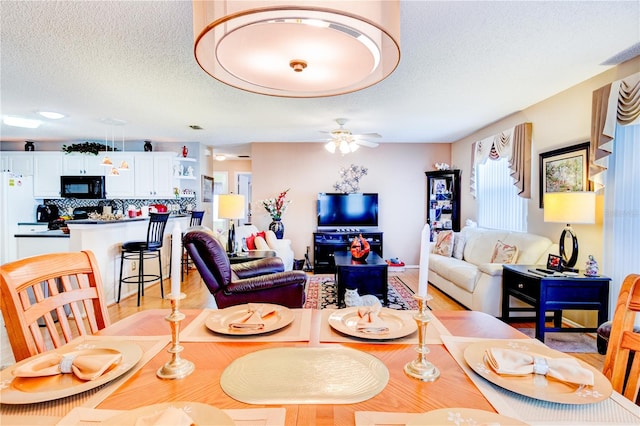 dining room with a textured ceiling and ceiling fan