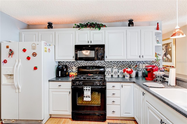 kitchen featuring tasteful backsplash, white cabinetry, black appliances, and decorative light fixtures