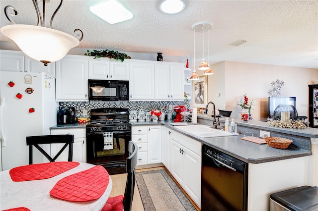 kitchen with hanging light fixtures, white cabinetry, backsplash, black appliances, and sink