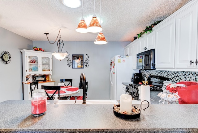 kitchen featuring tasteful backsplash, white cabinetry, black appliances, a textured ceiling, and hanging light fixtures