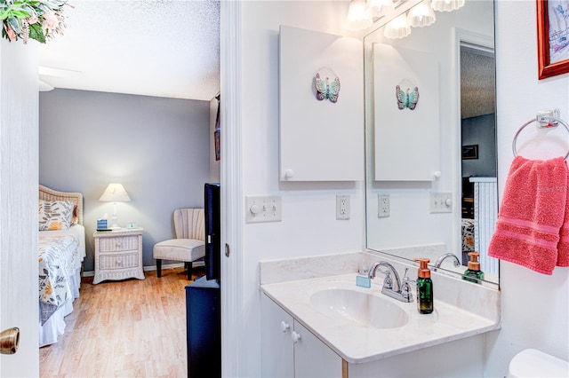 bathroom featuring wood-type flooring, a textured ceiling, and vanity